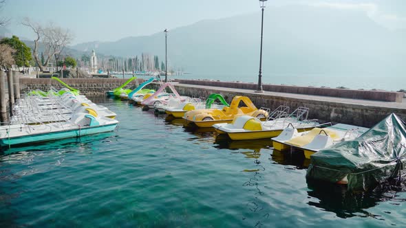 Colorful Touristic Boats Moored to Bank Against Mountains