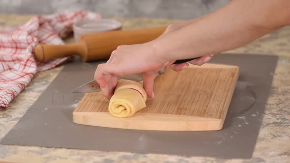 Chef Cuts with a Knife in Equal Portions for Baking Crispy Buns