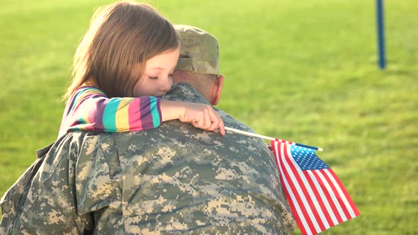 American Soldier Reunited with Daughter on a Sunny Day Outdoor.