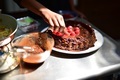 Candid Lifestyle Photo of a Young a Girl decorating a Chocolate Cake with Fresh Red Raspberry - PhotoDune Item for Sale