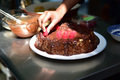 Candid Lifestyle Photo of a Young a Girl decorating a Chocolate Cake with Fresh Red Raspberry - PhotoDune Item for Sale
