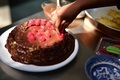 Candid Lifestyle Photo of a Young a Girl decorating a Chocolate Cake with Fresh Red Raspberry - PhotoDune Item for Sale