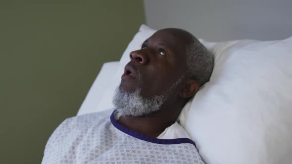 African american male patient lying in hospital bed and yawning