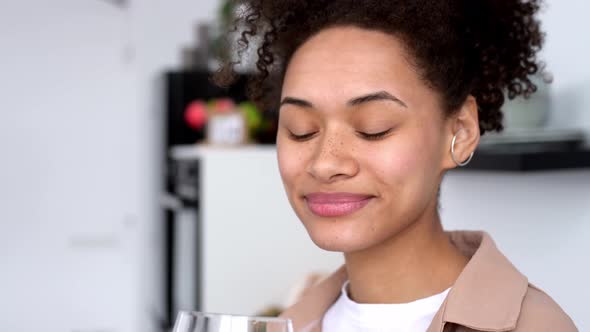 Satisfied African American Girl with Curly Hair Takes Care of Her Health Drinks Clean Water with