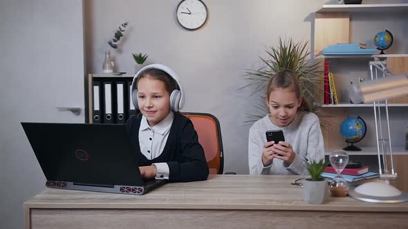 Teen Girls Playing Video Game on Laptop and Phone Simultaneously and Celebrating Victory