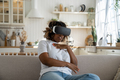 Afraid black woman in 3D VR glasses sits at home feeling excited, overwhelmed by watch horror movie - PhotoDune Item for Sale