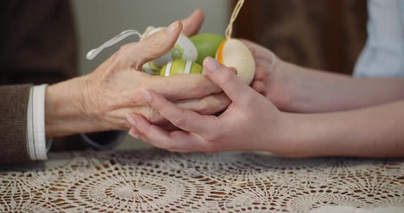 Woman and Senior Man Holding Easter Eggs in Hands