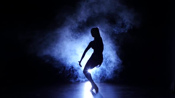 Graceful Girl Dancing in Studio, Silhouette. Dark Background, Blue Backlight