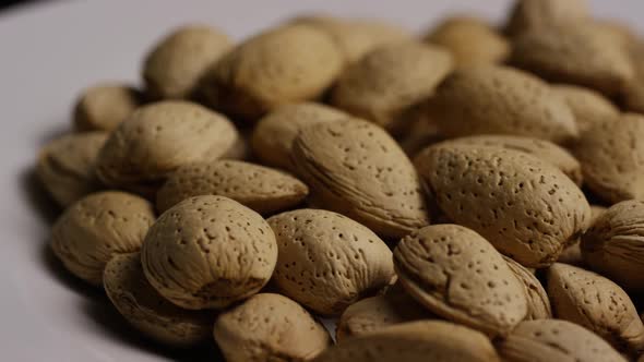 Cinematic, rotating shot of almonds on a white surface 