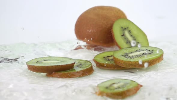 A Several Slices of Kiwi are Falling on the Table