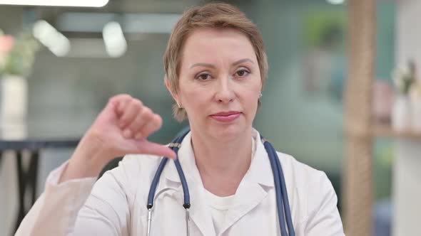 Disappointed Middle Aged Female Doctor Showing Thumbs Down