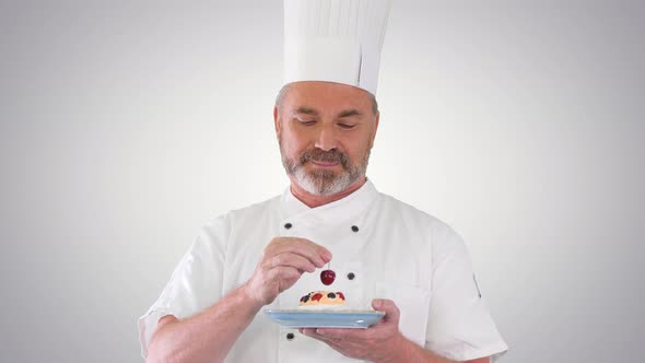 Chef Putting Cherry on Top of the Cake Before Serving It Icing on the Cake on Gradient Background