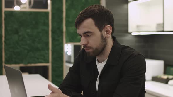 Young Focused Handsome Male Businessman Working on a Laptop