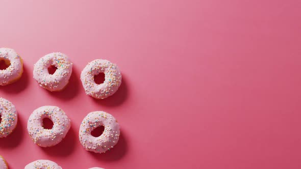 Video of donuts with icing on pink background