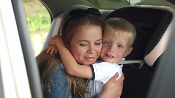 Portrait of a Happy Mother with Her Son in the Car the Boy in the Car Seat