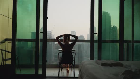 A Girl Sits on the Balcony