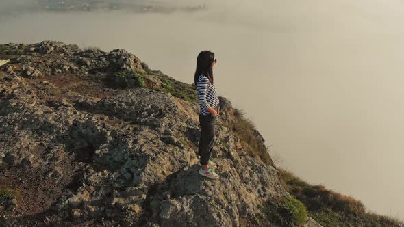 Positive Woman On The Edge Smiles Above Clouds