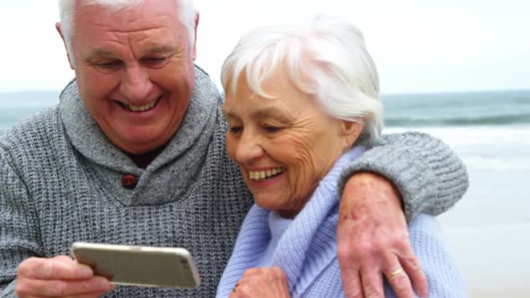 Senior couple checking photos on mobile phone