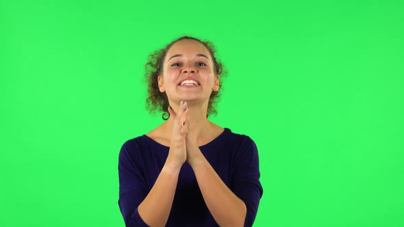 Portrait of Curly Woman Keeping Palm Together and Asking for Something. Green Screen