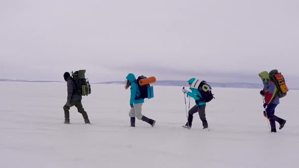 Side View Shot of a Group of Sportsmen Trekking in Winter.