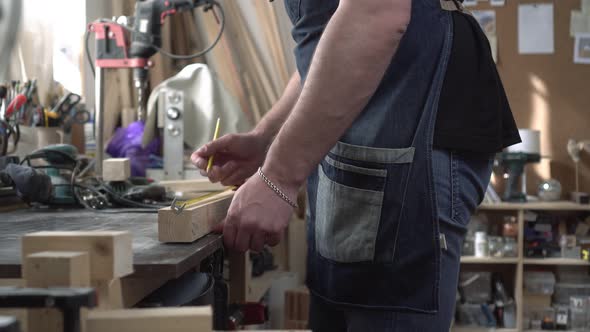 A Man Works in a Carpentry Workshop with Wood