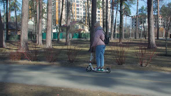 Woman Riding Kick Scooter In Park