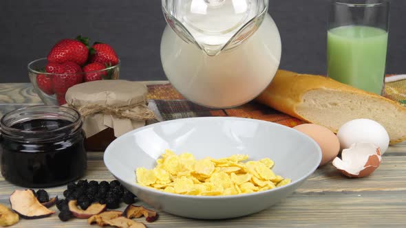 Breakfast. Pouring milk into corn flakes