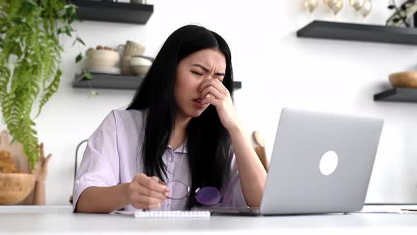 Tired Exhausted Asian Brunette Girl Tired of Working in a Laptop Experiencing Stress Headache