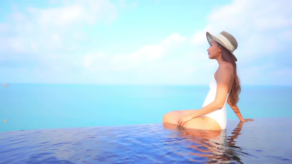 Young asian woman enjoy around outdoor swimming pool for leisure