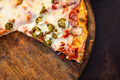 Pizza on a wooden board with a slice missing - PhotoDune Item for Sale