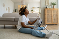Tired overheated black woman cooling herself with electric fan at home - PhotoDune Item for Sale