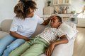 Attentive black woman touch forehead of sick child son sit at home sofa feel unwell weakness malaise - PhotoDune Item for Sale