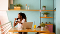 Young black woman drinking coffee  while working on laptop in the cafe - PhotoDune Item for Sale