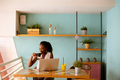 Young black woman drinking coffee  while working on laptop in the cafe - PhotoDune Item for Sale