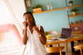 Young black woman using mobile phone in the cafe - PhotoDune Item for Sale
