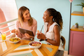Young black and caucasian woman having good time, drinking fresh juices and having healthy breakfast - PhotoDune Item for Sale