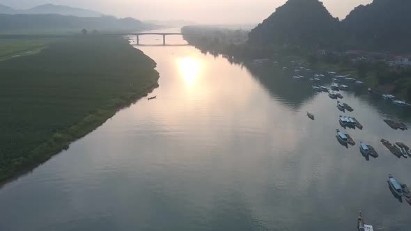 Flycam Films Calm River Surface Under High Narrow Bridge