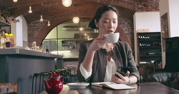 Woman Drinking Tea Using Smartphone Mobile