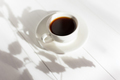 Espresso in a white cup on a white table in bright sunlight. - PhotoDune Item for Sale
