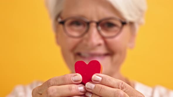 Close Up. Happy Senior Woman Showing the Heart Shape Between Her Fingers. Emotion Love and Support