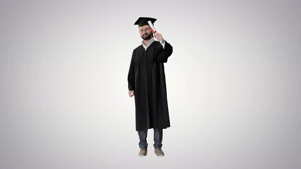 Happy Student Wearing the Graduation Robe and Holding His Certificate and Raising His Thumb Up 