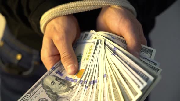 Male Hand Bound with the Rope Holding Pile of Money American Dollar Bank Notes, Financial