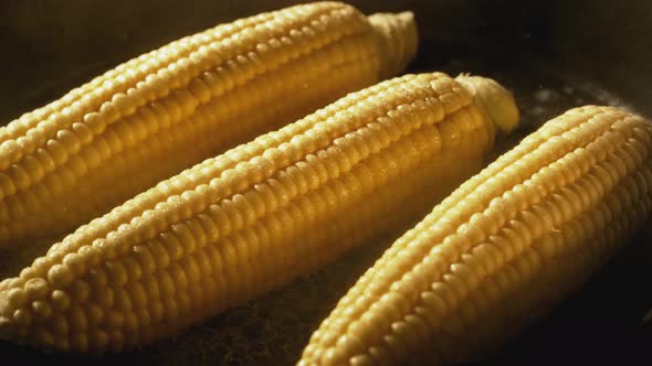 Cooking corns in fry pan. Slow Motion. alt