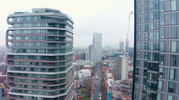 Dolly back aerial drone shot through London skyscrapers City road Angel