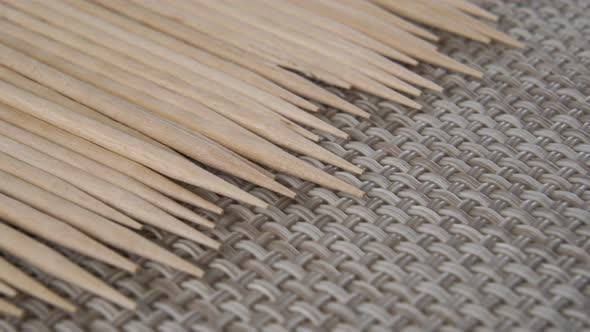 Sharpened wooden new toothpicks are stacked in a row on a braided kitchen napkin