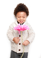 Cute child holding a big pink flower and looking at it - PhotoDune Item for Sale