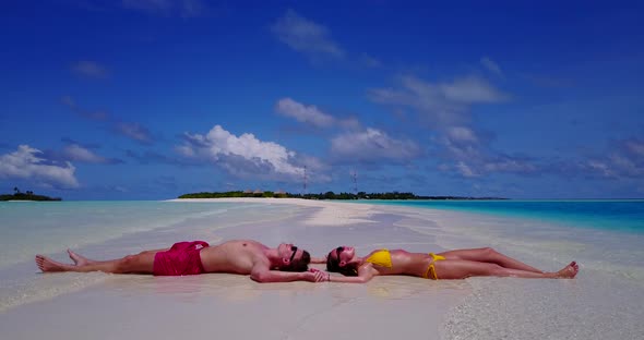 Romantic boy and girl on honeymoon vacation enjoy luxury on beach on white sand background 