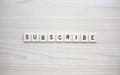 Subscribe letter tiles on a wood grain background - PhotoDune Item for Sale