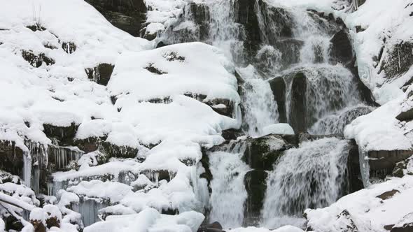 Small Streams of Cold Water Flow Among the Stones Covered with Snow