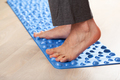 man doing flatfoot correction gymnastic exercise walking on massage mat at home - PhotoDune Item for Sale